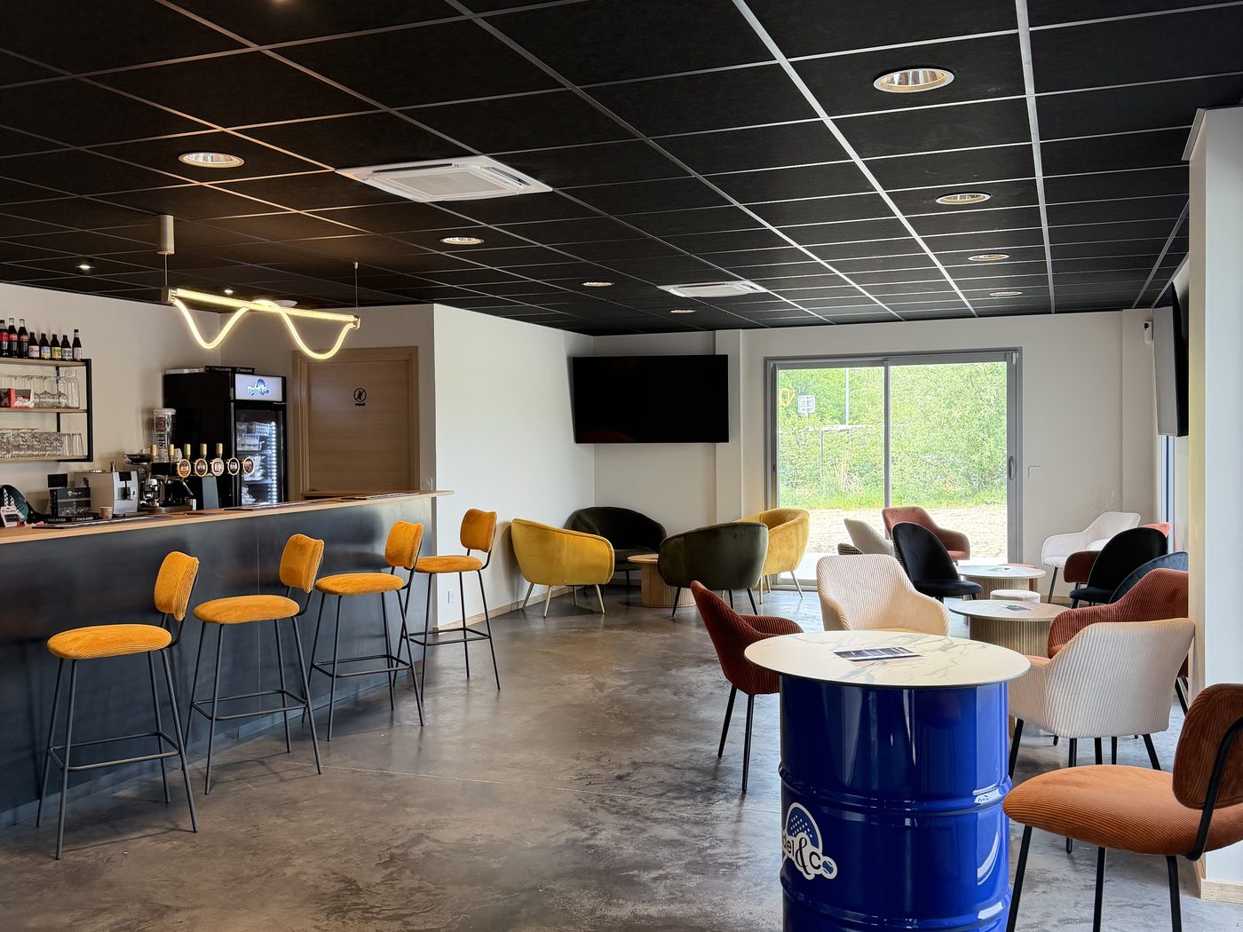 Les fauteuils colorés du club-house devant la baie vitrée