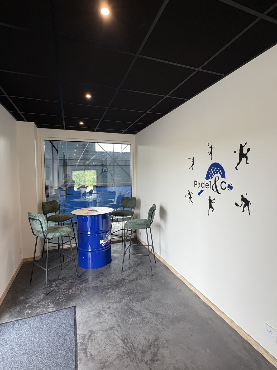 Le coin salon du club-house et sa fresque murale Padel and Co